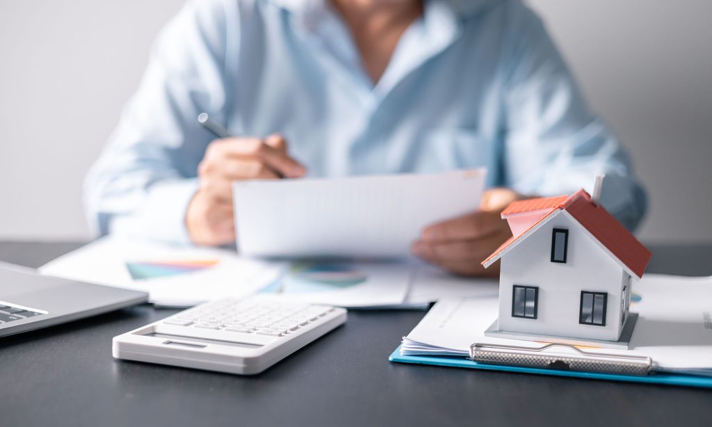 House with money. Concept of finance or refinance real estate. Symbol of house stands against background of us dollars. Property investment. Home mortgage loan rate. Saving money for retirement.